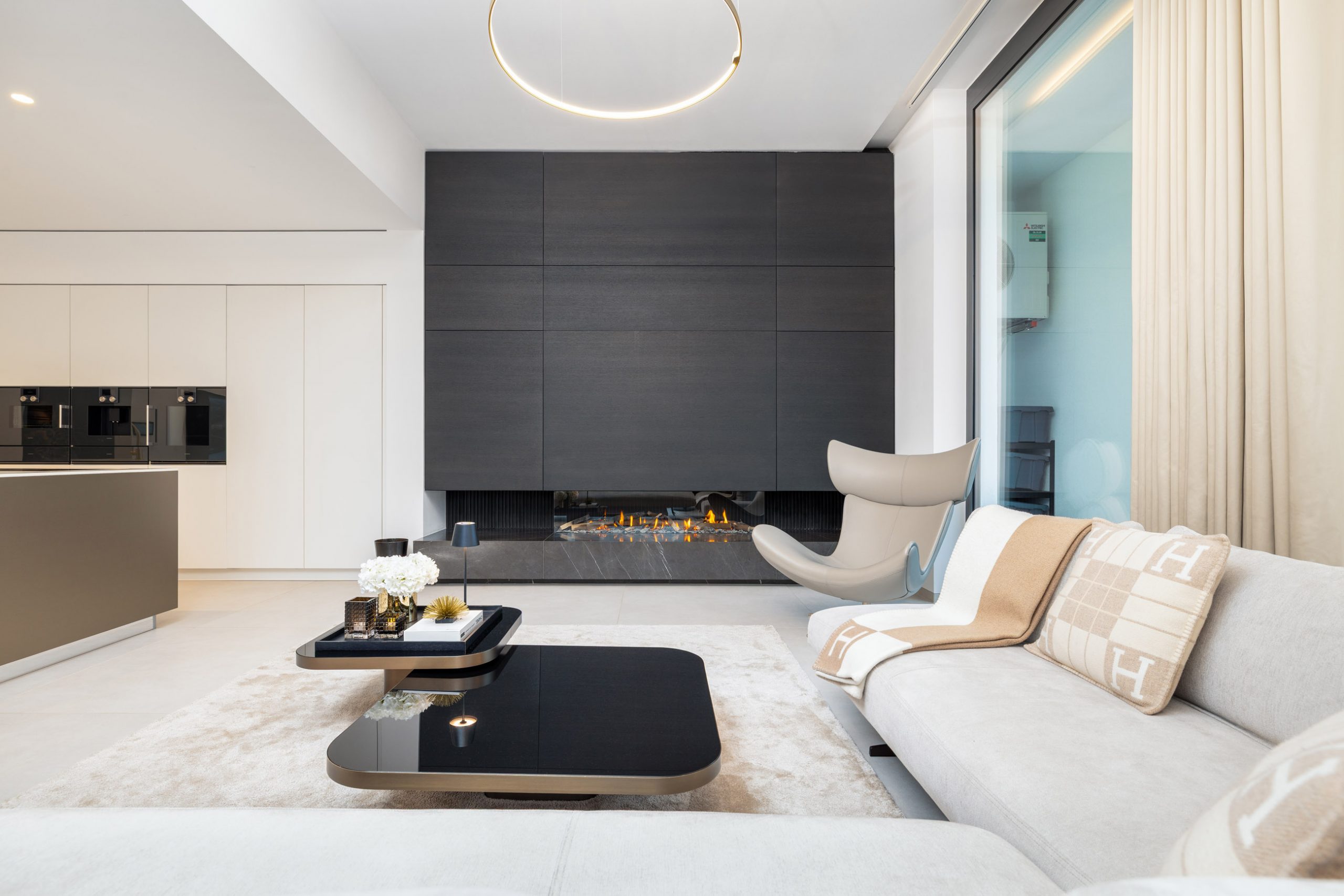 Moderner Wohnbereich mit hellem Sofa, Couchtisch und großen Fenstern